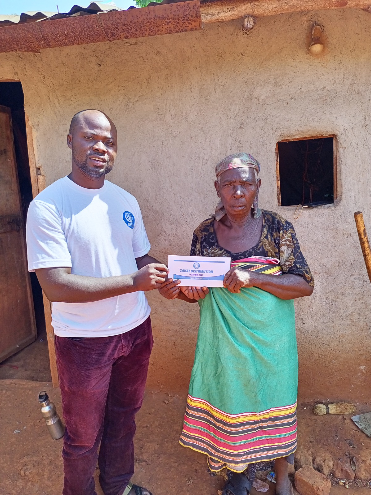Zakat distribution with beneficiary holding a sign