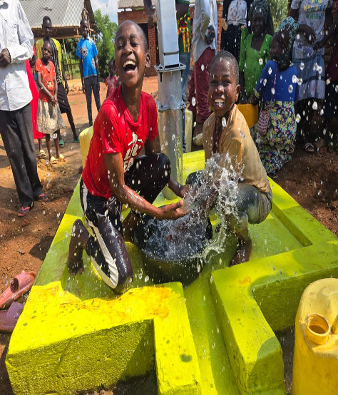 Children celebrating clean water at a newly installed hand pump in Uganda
