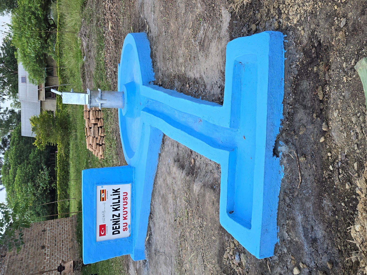 Completed borehole with blue concrete base and plaque